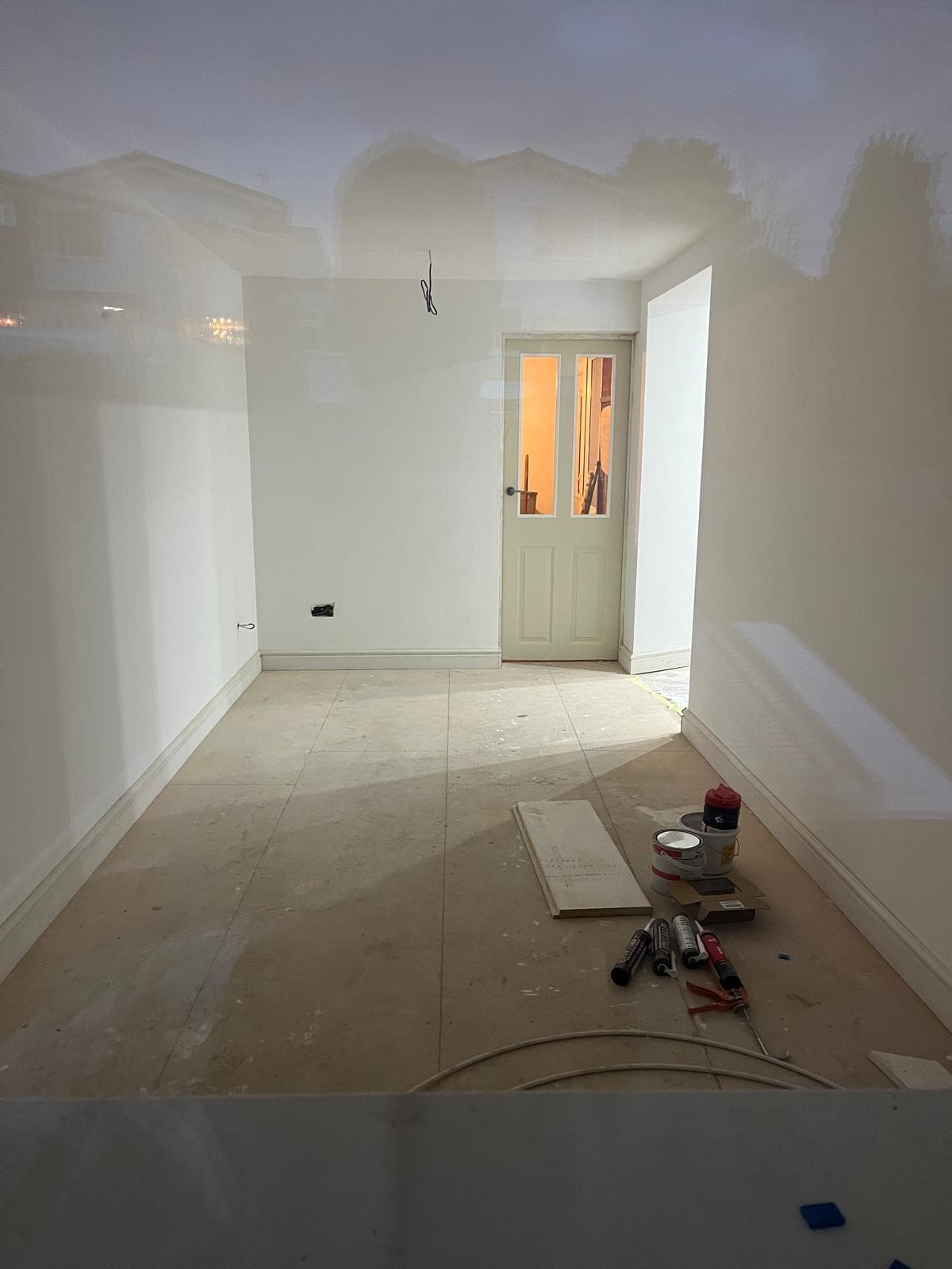 The converted garage plastered out, with a new internal door and the floor prepared before flooring is laid